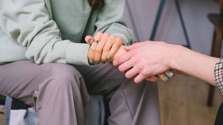 Dos personas cogidas de la mano.