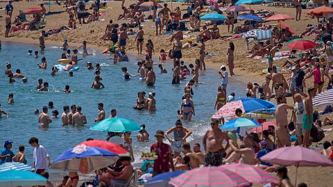 Nadadores se refrescan en el agua en una playa en un día caluroso en Barcelona, España, sábado 28 de junio de 2025.