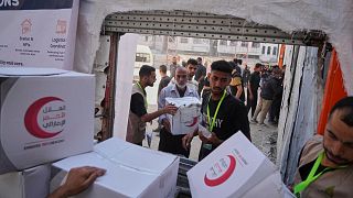 FILE: Palestinians receive food parcels in Gaza City, 26 June 2025
